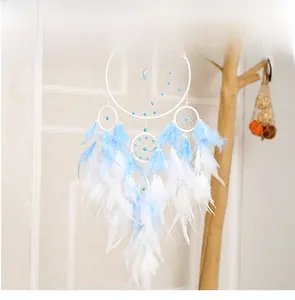 Blue and white dreamcatcher detail featuring soft feathers and woven beads in a home setting