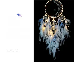 Detail of dream catcher with blue gradient feathers and warm LED light decoration