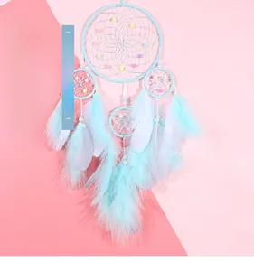 Detailed view of mint green dream catcher with intricate webs and soft feathers