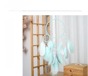 Macro view of mint blue dream catcher with intricate mesh weaving and soft feathers