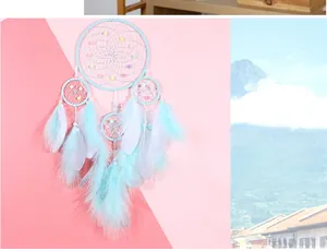 Detail of light blue dream catcher with natural feathers and delicate beads for wall decor