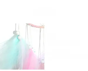 Close-up of handmade dreamcatcher with soft pastel feathers and white decorative beads