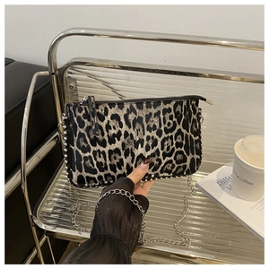 Detail of leopard print shoulder bag with silver studs and metal chain strap on display