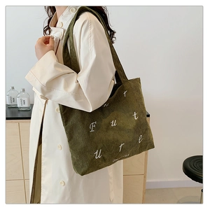 Detail of army green corduroy tote bag featuring white embroidered Future lettering