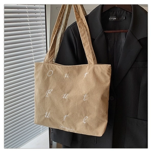 Detail view of khaki corduroy tote bag with Our Future embroidery and soft shadow texture