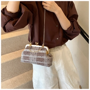 Detail of vintage brown plaid frame bag with white lace trim and gold chain strap