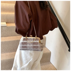 Close-up of retro shell bag featuring brown plaid fabric and delicate white lace trim