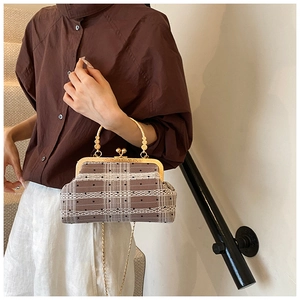 Close-up of vintage plaid shell bag with gold handle and polka dot lace pattern