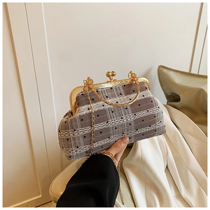 Close-up of retro grey checkered lace bag with gold frame and chain strap handle