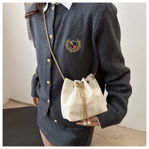 Détail du sac seau plissé blanc avec bandoulière chaîne dorée et breloques en perles