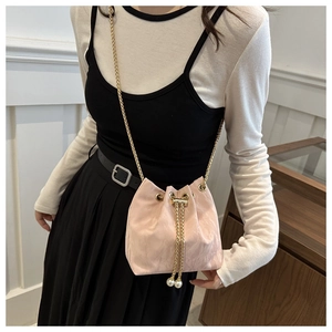 Détail du sac seau rose à cordon avec bandoulière dorée et détails de perles