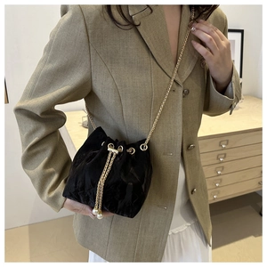 Minimalist black velvet bucket bag with gold chain strap and pearl drawstring details