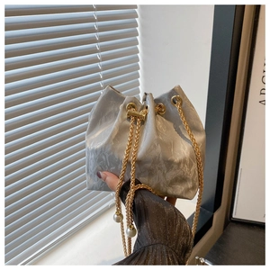 Détail du sac seau gris effet marbre avec bandoulière dorée et perles décoratives