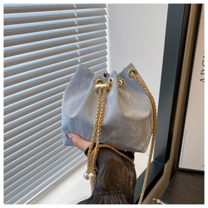 Vue détaillée du sac seau marbré bleu clair avec chaîne dorée et perles décoratives