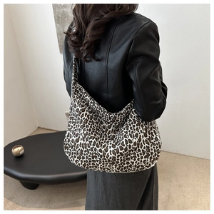 Détail d'un grand sac hobo avec motif léopard porté sur l'épaule du modèle