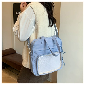 Detailed side view of light blue nylon tote bag with transparent mesh front pocket