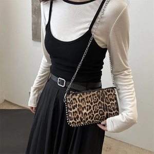 Minimalist leopard print crossbody bag with silver studs and chain strap on model