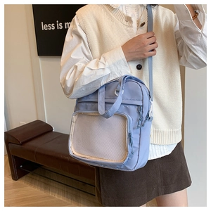 Close-up of light purple canvas crossbody bag featuring a transparent mesh front pocket