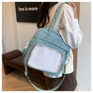 Light blue nylon crossbody tote with a clear PVC window and white grid layer detail