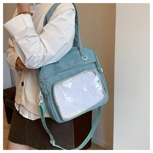 Detail view of light blue ita bag with transparent window for pins on a model