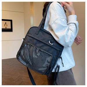 Detail of black canvas backpack with clear PVC pocket and contrast white plastic buckles