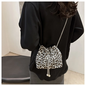 Detail of leopard print bucket bag with silver chain strap and drawstring closure