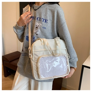 Close-up of white tote bag featuring a transparent display window and mesh pocket detail