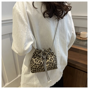Detail of leopard print bucket bag with metal chain strap and pearl drawstring charms