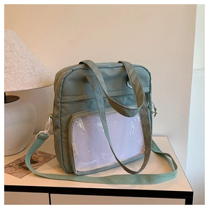 Close-up of mint green nylon tote with mesh front pocket and adjustable strap