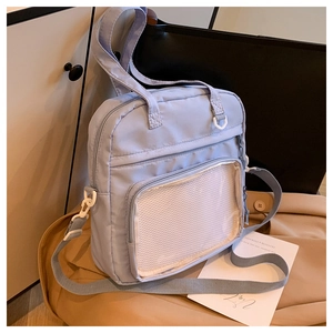 Detail of periwinkle nylon crossbody bag featuring a transparent mesh front pocket