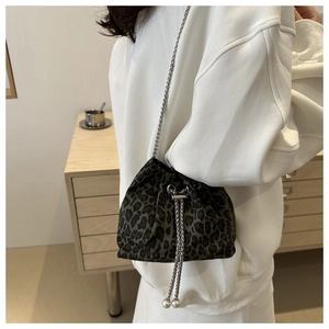 Detail of leopard print bucket bag featuring pearl charms and a silver chain strap