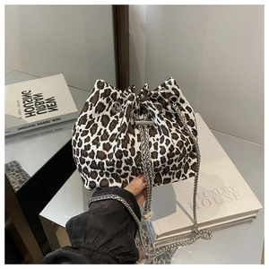Detail of leopard print bucket bag with metal chain strap and pearl accents