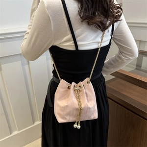 Sac seau plissé rose avec chaîne dorée et perles porté par un mannequin de dos
