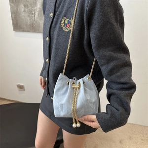 Sac seau bleu clair à cordon avec texture marbre, détails perles et bandoulière chaîne or