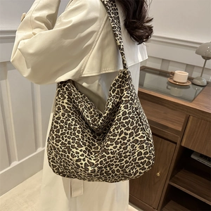 Sac fourre-tout chic en toile à imprimé léopard porté à l'épaule par un mannequin