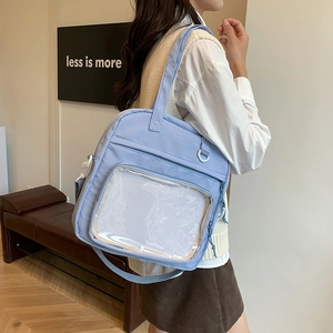 Light blue canvas tote bag with transparent PVC front pocket and adjustable strap