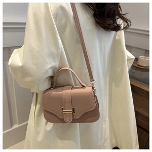Detail of dusty pink lychee grain leather crossbody bag with elegant gold metal buckle