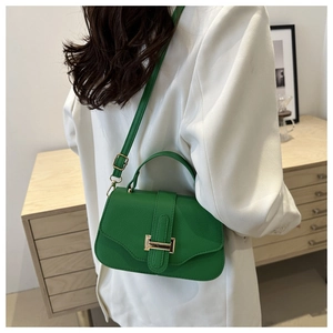 Detail of green litchi texture small square bag with gold H-clasp and strap on shoulder