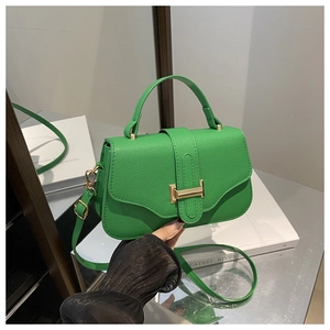 Detail of green litchi grain leather bag featuring gold H clasp and top handle grip