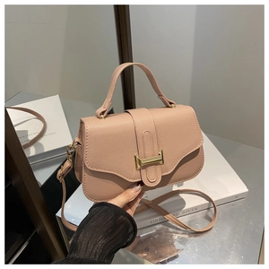 Close-up of pink litchi grain leather flap bag with gold clasp and single top handle