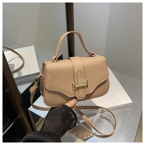 Detail of beige pebbled leather texture and elegant gold H-shaped buckle on small square bag