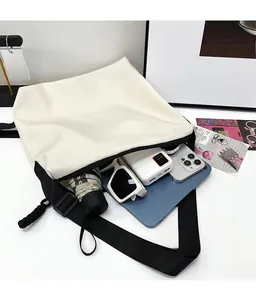 Vue détaillée de l'intérieur spacieux de ce sac fourre-tout en toile blanc cassé avec objets