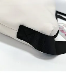 Détail des coutures renforcées en croix sur le sac cabas en toile blanc cassé et nylon