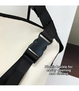 Vue détaillée de la boucle en plastique noir et de la sangle en nylon du sac cabas crème