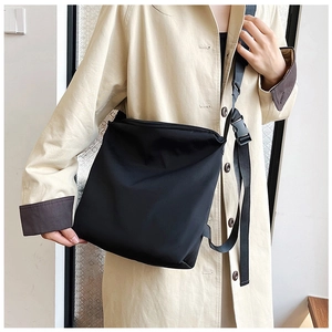 Détail de la bandoulière réglable et de la boucle d'un grand sac cabas noir en nylon