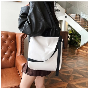 Vue détaillée du grand sac cabas blanc avec sangles noires contrastées et design épuré