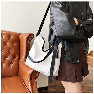 Vue détaillée du grand sac cabas blanc avec une large bandoulière noire réglable
