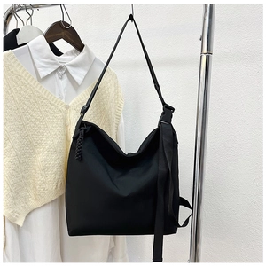 Détail du sac fourre-tout en nylon noir avec boucles tactiques et tirettes de zip tissées