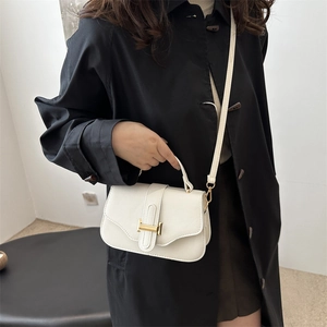 French vintage off-white leather underarm bag with gold metal clasp on a model