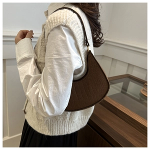 Brown crocodile embossed hobo bag worn as a shoulder bag with minimalist outfit